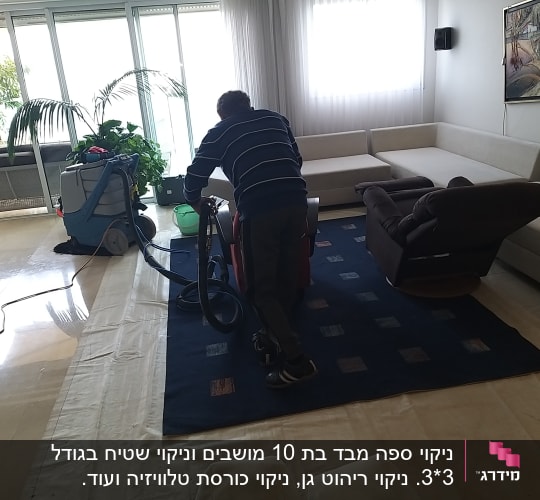 אדם מנקה שטיח עם מכונת ניקוי מקצועית